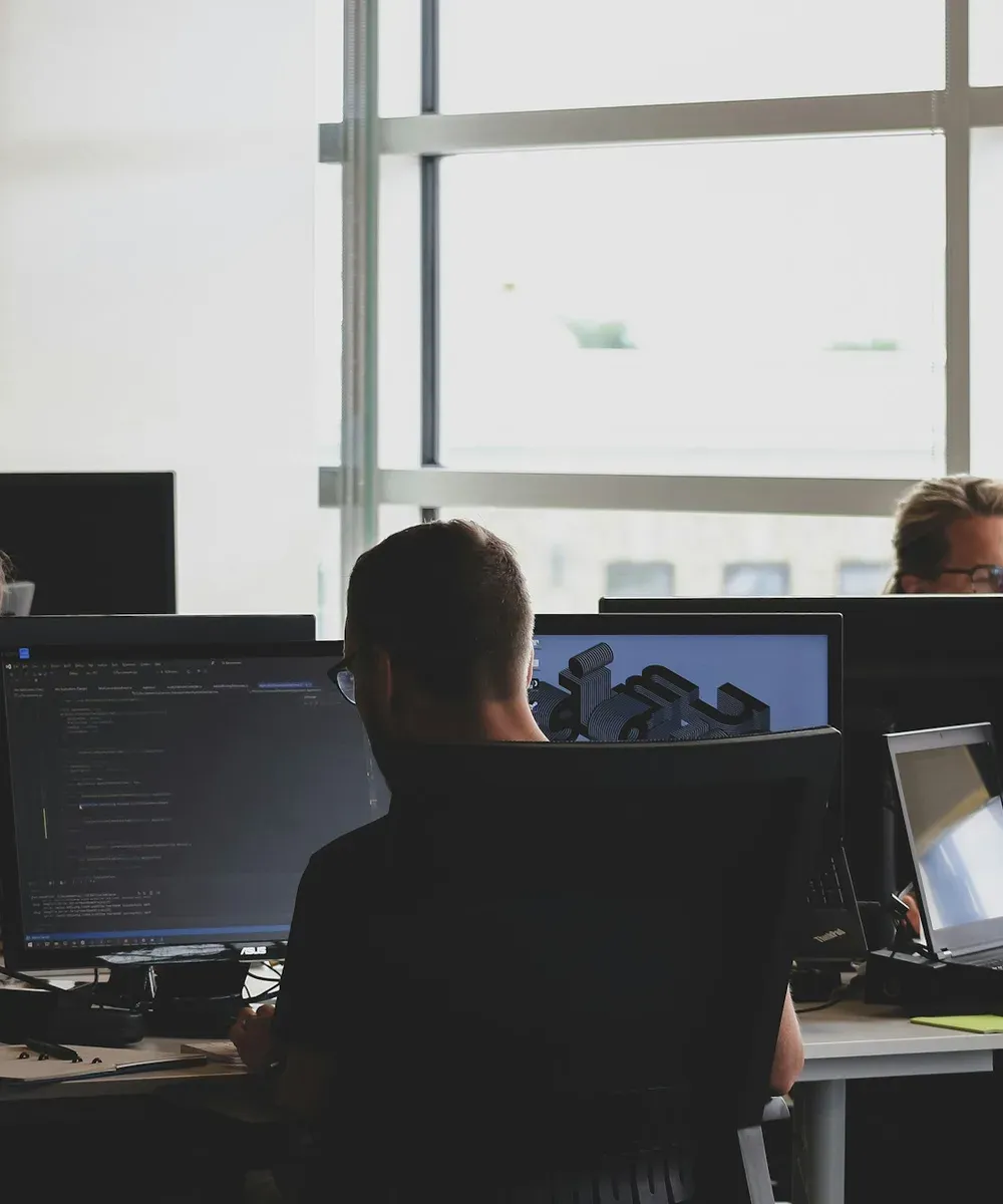 An engineer on watch at a multi-screen workstation.