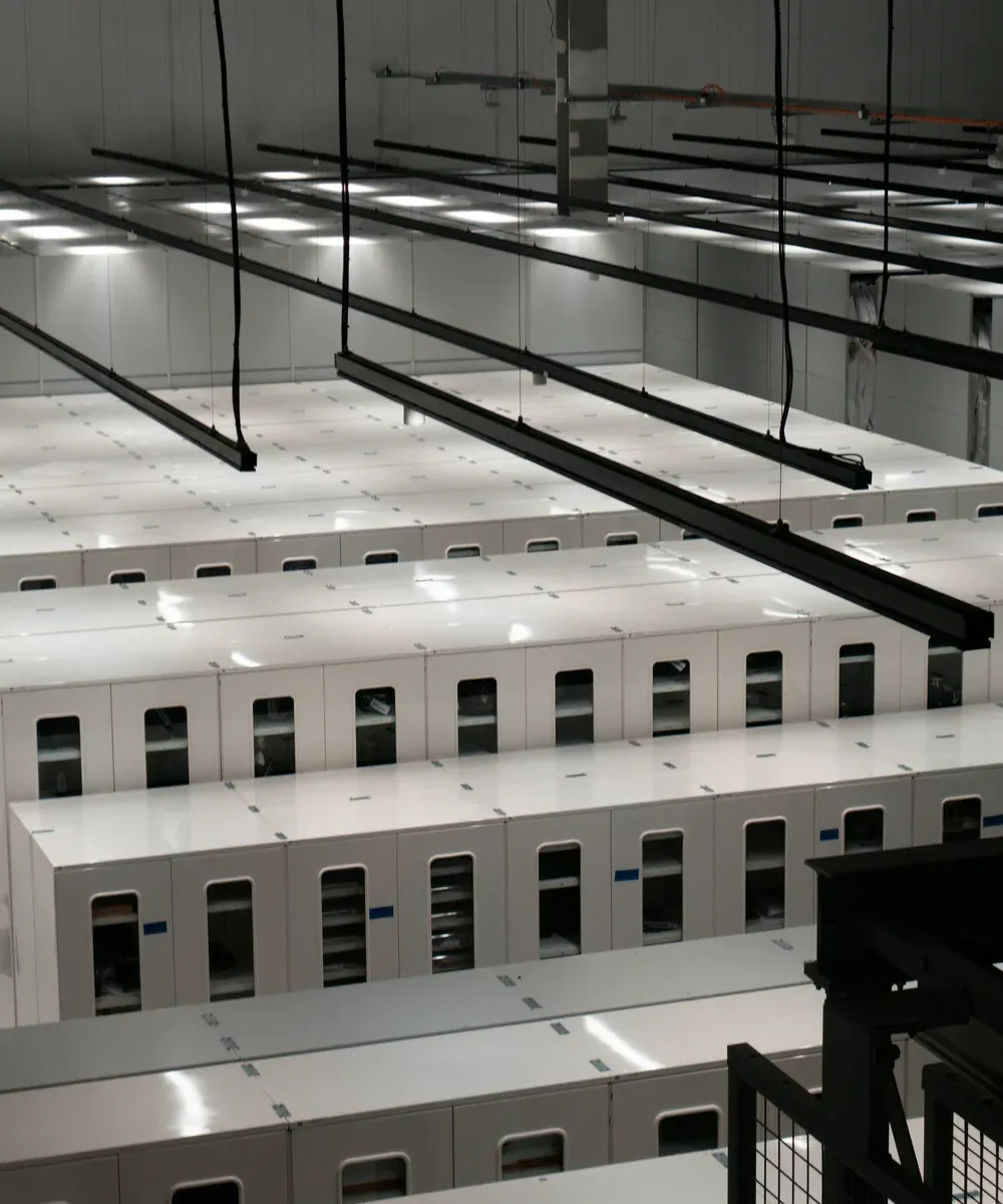 An unattended data hall with rows of white cabinets.