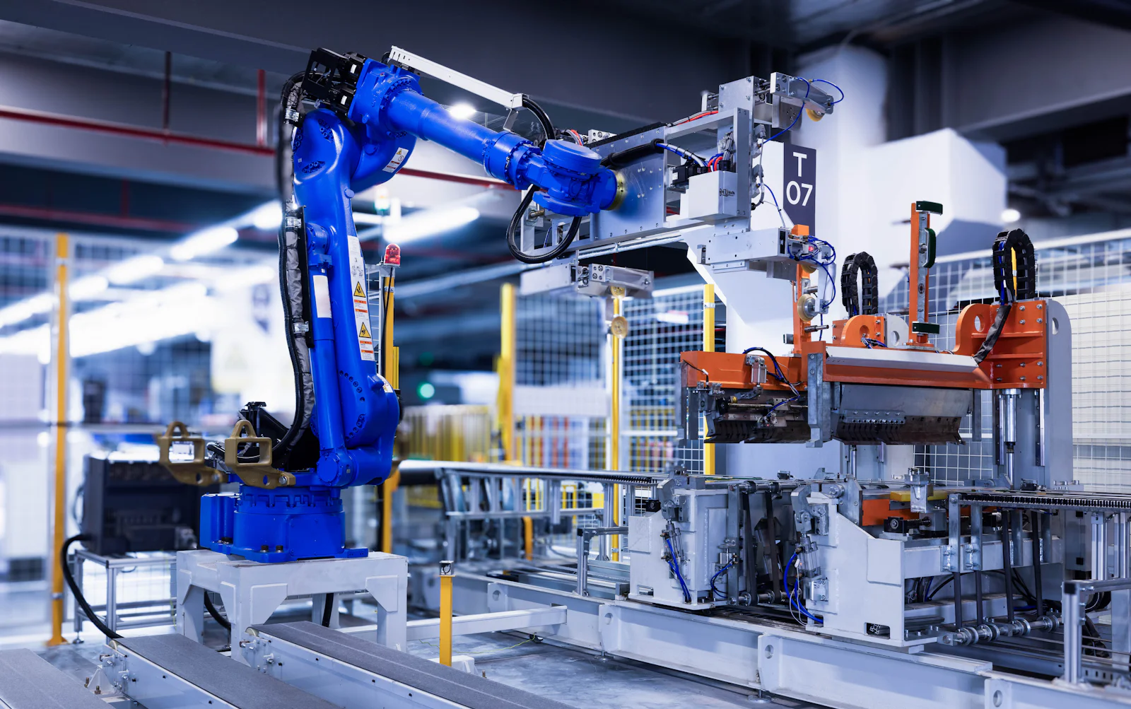 A blue industrial robot arm on a factory production line